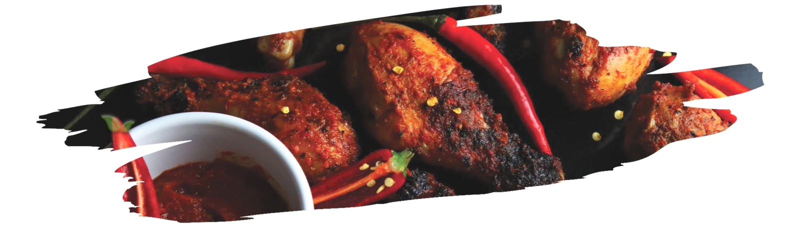 Grilled chicken marinated in peri peri sauce with sauce bottle and chilies nearby