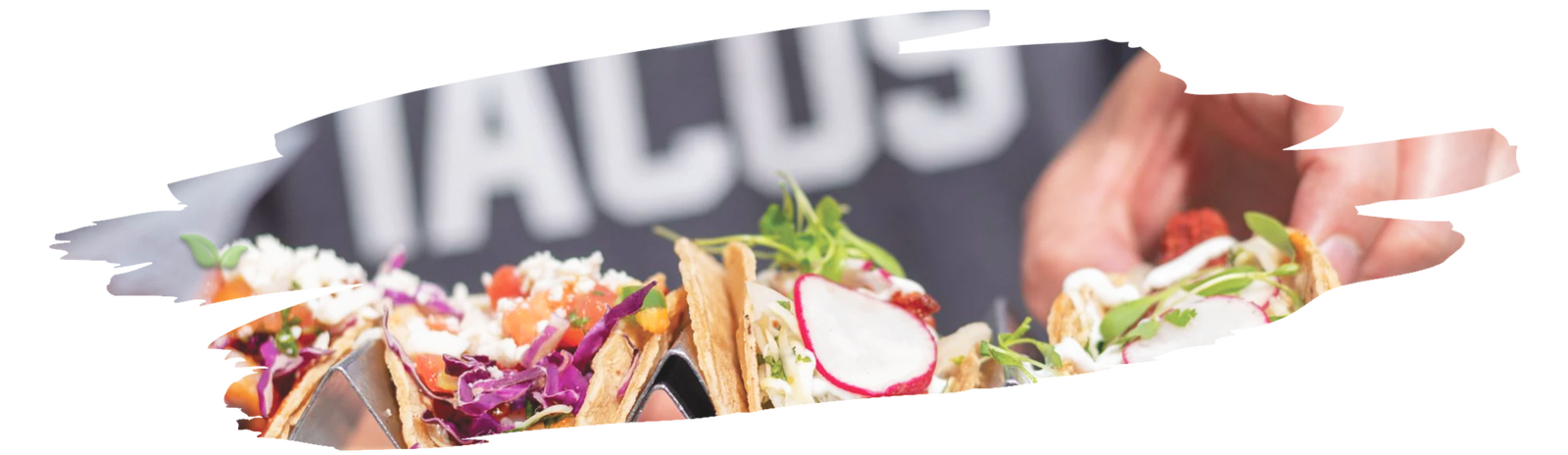 Measuring spoons filled with spices for making homemade taco seasoning on wooden table