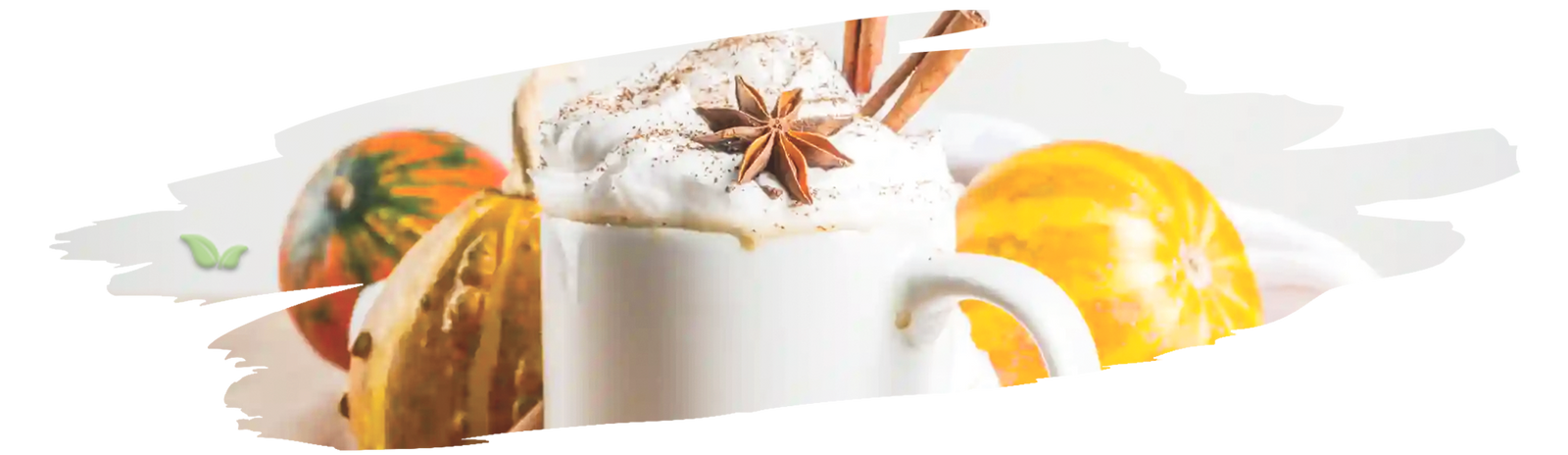 Barista pouring steamed milk into mug of pumpkin spice latte with fall spices nearby