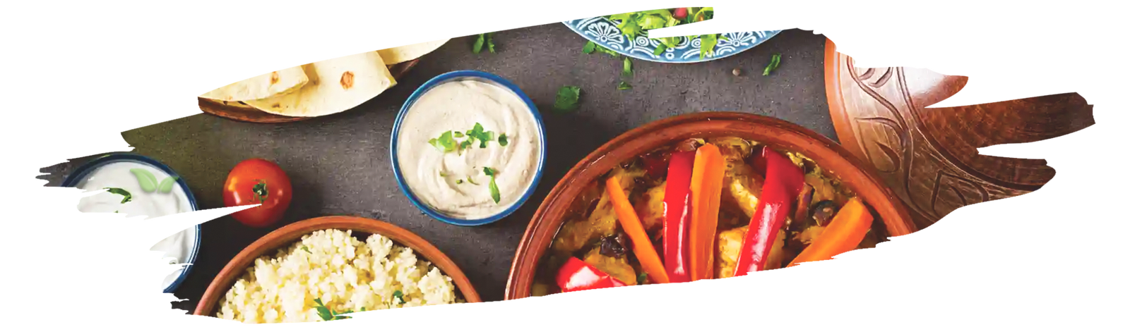 Variety of vibrant ground spices arranged around fresh herbs for healthy cooking