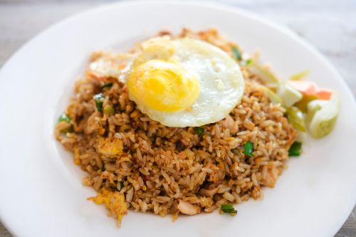 indonesian nasi goreng fried rice showing golden color and fried egg on top