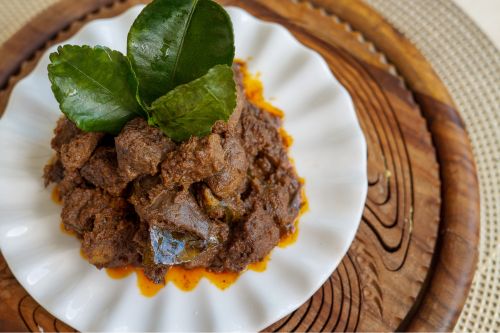 plate of malaysian beef rendang showing dark rich curry saucee