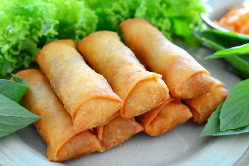 plate of crispy spring rolls with dipping sauce showing golden fried texture