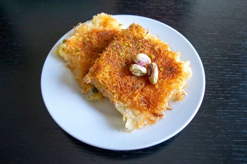 tray of kunafa dessert showing golden shredded pastry and syrup glaze