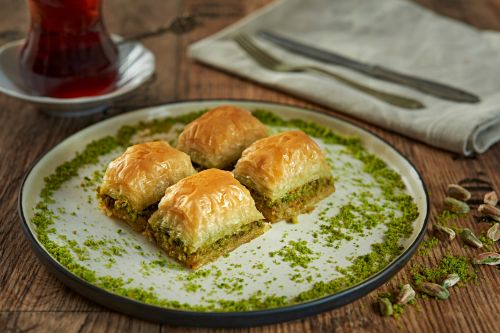 tray of golden baklava showing layers of phyllo dough and pistachio filling