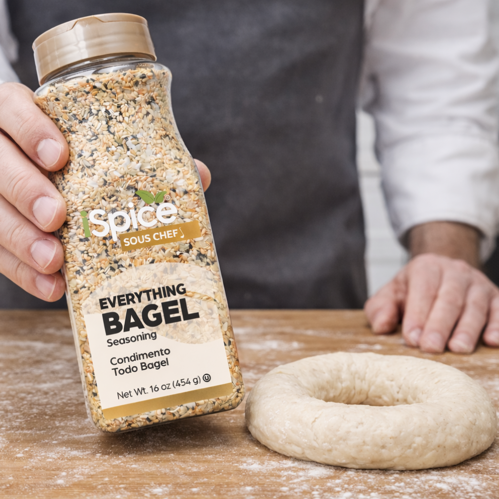 Spice Sous Chef Everything Bagel seasoning bottle held by a person with dough on a wooden surface.