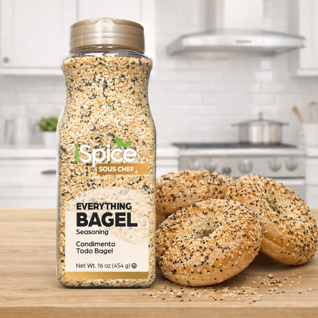 Spice bottle labeled 'Everything Bagel' seasoning with bagels on a wooden surface in a kitchen setting.