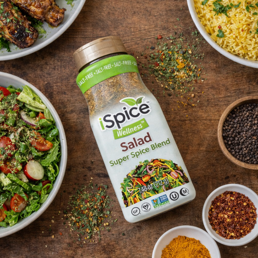 iSpice Wellness Salad Super Spice Blend bottle on a wooden table with various spices and salads.