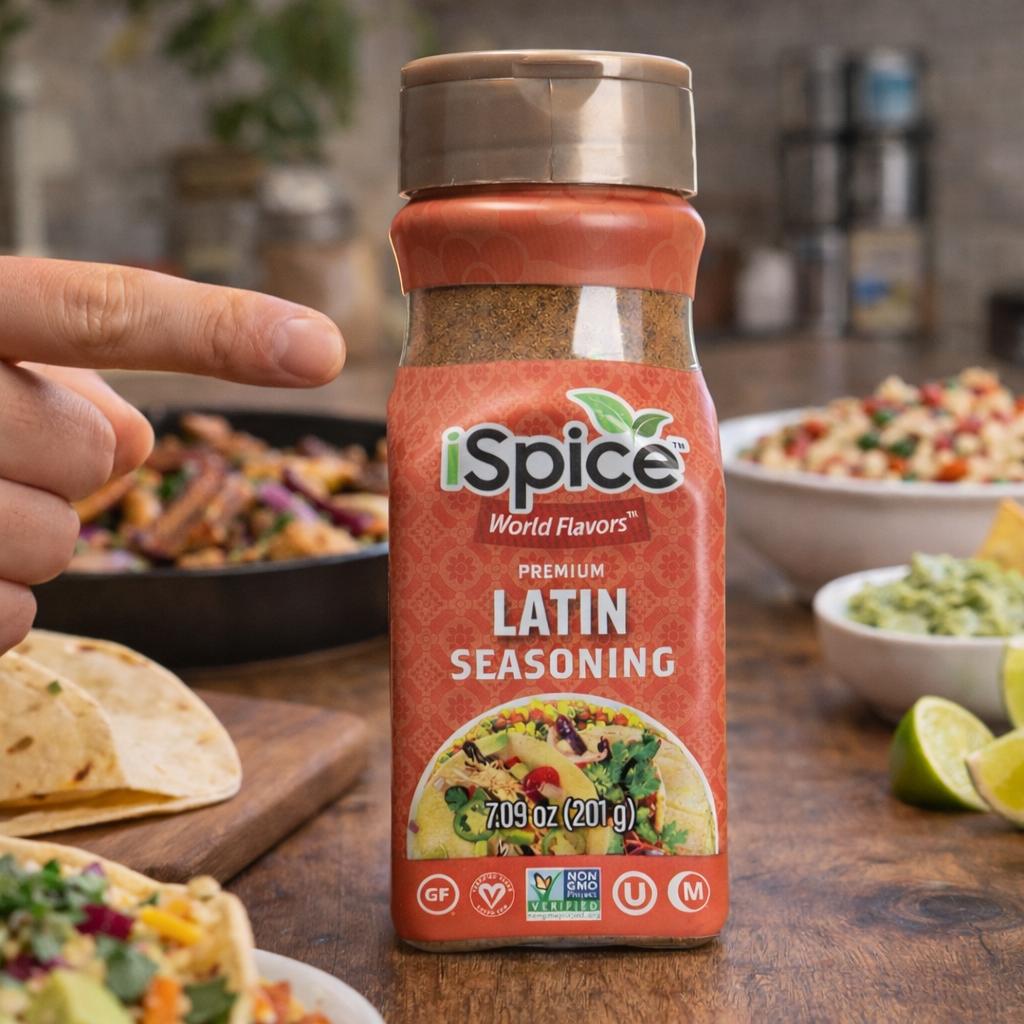Bottle of Spice World Flavors Latin seasoning with a hand pointing to it, set against a kitchen backdrop.